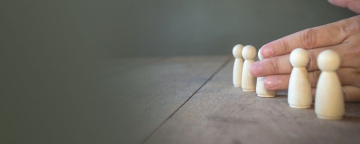 hand prevents a wooden doll from its group